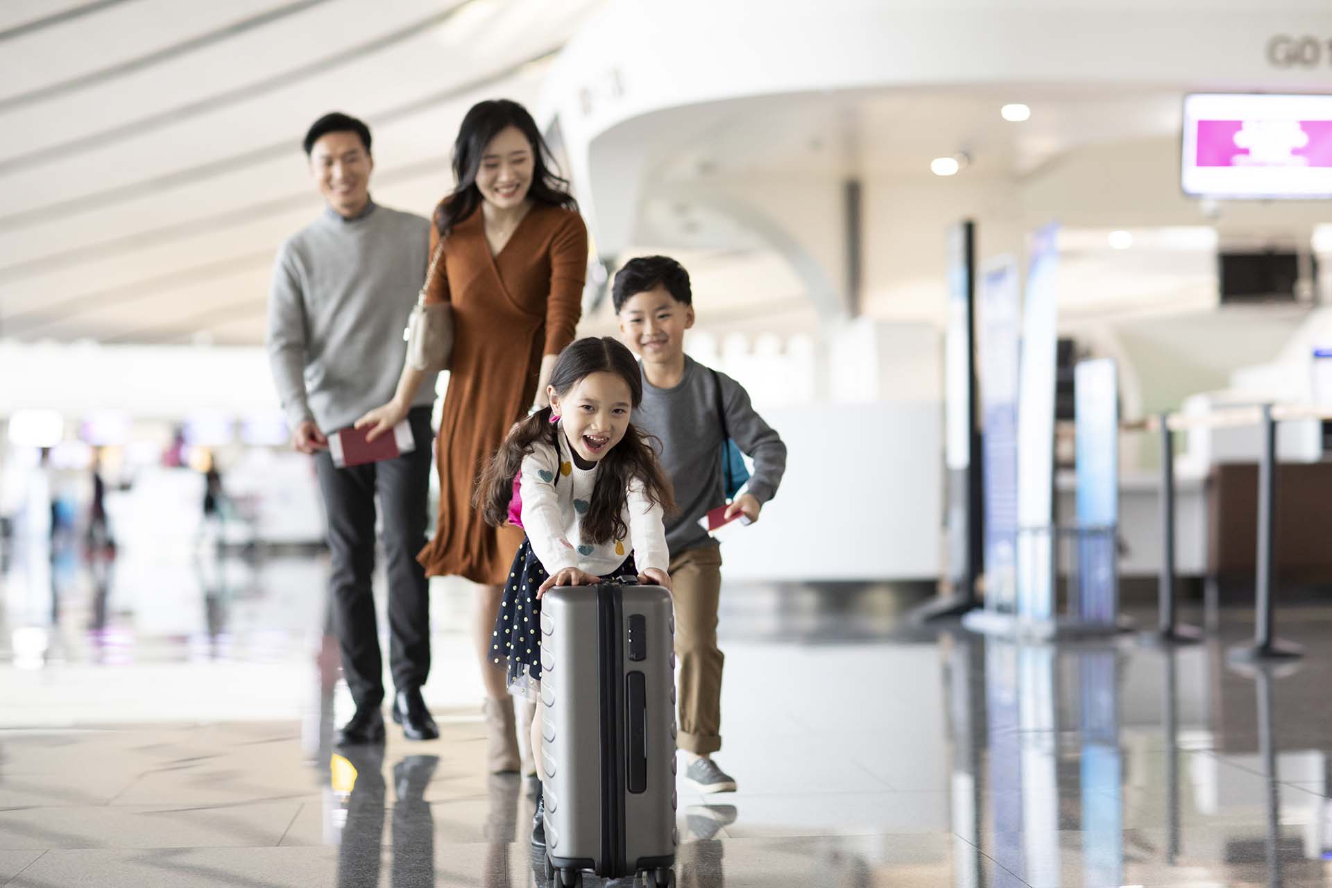 Happy young Chinese family travelling from airport